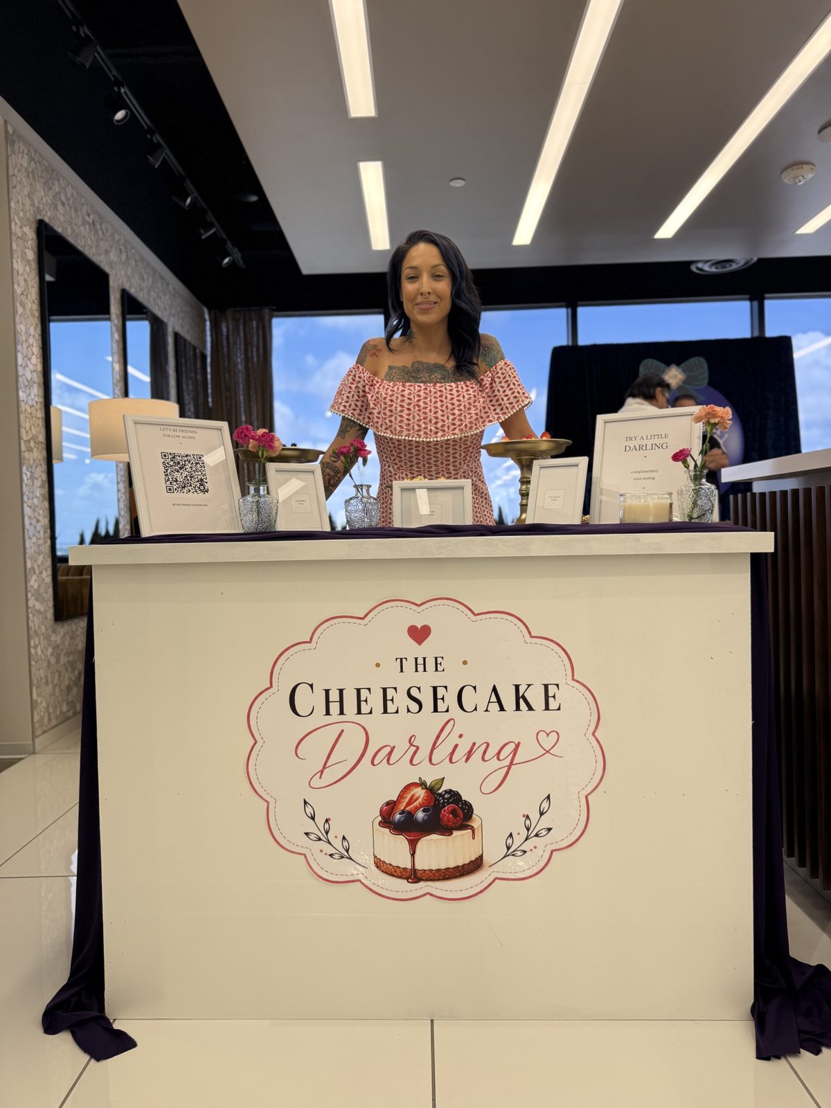 Jessica at her vintage-styled dessert booth with blush floral branding